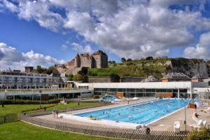 Suite Melody double balnéo, home-cinéma, terrasse à Dieppe في دْييب: حمام سباحة كبير مع قلعة في الخلفية