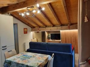a living room with a table and a blue couch at Chalet la sapiniere in La Chapelle-dʼAbondance
