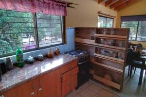 a kitchen with wooden cabinets and a stove top oven at Casa de Costa, Campo y Relax in Algarrobo