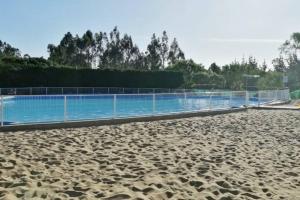 a large swimming pool with a sandy beach at Casa de Costa, Campo y Relax in Algarrobo