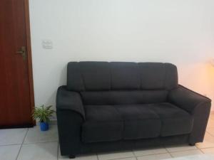 un sofá negro sentado en una sala de estar en Sua casa na praia em Cabo Frio, en São Pedro da Aldeia