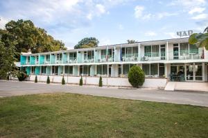 un ancien bâtiment blanc avec un balcon et une rue dans l'établissement Hotel Char, à Primorsko