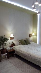a bedroom with a bed and a table with a plant at Diána Apartmanház in Keszthely