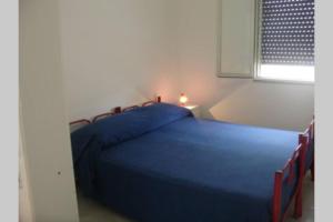 een blauw bed in een kamer met een raam bij Villetta sul Mare a Gallipoli Padula Bianca in Alezio