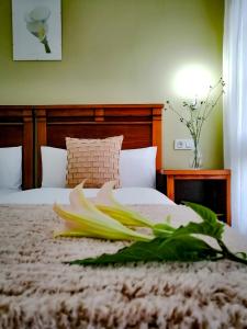Un dormitorio con una cama con una flor. en Hotel Pugide en Llanes