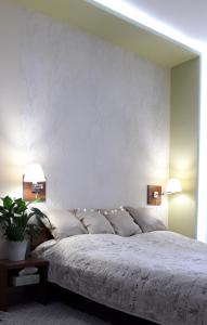 - une chambre avec un grand lit blanc et deux lampes dans l'établissement Diána Apartmanház, à Keszthely