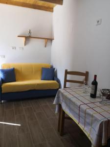 sala de estar con sofá amarillo y mesa en Live Masca - Estudio casas morrocatana Tenerife, en Masca