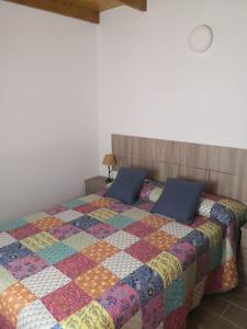 1 dormitorio con 1 cama con colcha colorida en Live Masca - Estudio casas morrocatana Tenerife, en Masca