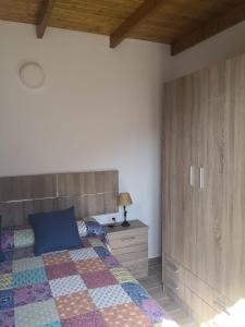 1 dormitorio con 1 cama con almohada azul y armario en Live Masca - Estudio casas morrocatana Tenerife en Masca