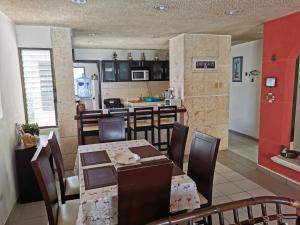 a dining room and kitchen with a table and chairs at Condominios Orca in Progreso