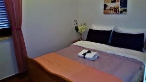 una camera da letto con un letto e un asciugamano sopra di VILLAMAR beachfront apartments with FREE private parking a Rabac