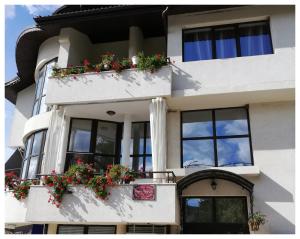 ein weißes Gebäude mit Blumenkästen an den Fenstern in der Unterkunft Guest House & Bistro Lefterova in Kotel