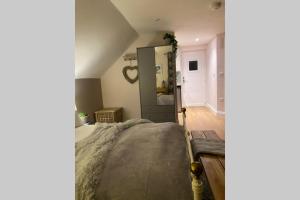 a bedroom with a large bed and a mirror at Prospect Perch - Studio Apartment, Wells in Wells