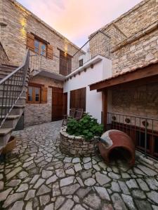 una casa con un patio de piedra con una escalera en Christiana's stone studios, en Pano Lefkara