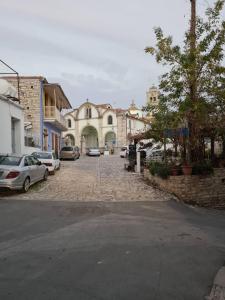 una calle de la ciudad con coches aparcados en la calle en Christiana's stone studios, en Pano Lefkara