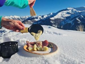 une personne déversant de la nourriture dans une assiette dans la neige dans l'établissement Résidence Saint-Jean, à Saint-Dalmas-le-Selvage