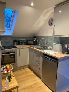 uma cozinha com utensílios de aço inoxidável e um lavatório em Prospect Perch - Studio Apartment, Wells em Wells