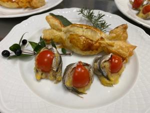 een bord met oesters en tomaten erop bij Hotel Ines in Varazze