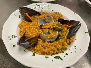 un plato de comida con marisco en una mesa en Hotel Ines en Varazze