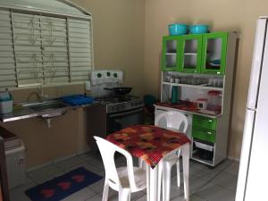 uma cozinha com uma mesa e um armário verde em CASA DE TEMPORADA NO JALAPÃO (CAP 11 PESSOAS) em Mateiros
