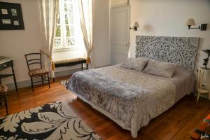 a bedroom with a bed and a desk and a window at L'Oustal in Bourges