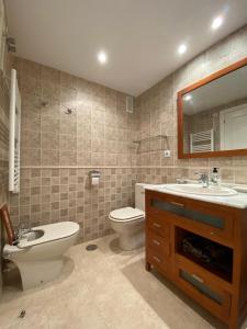 Un baño con inodoro, lavabo y espejo. en Apartamento Aguamar, en Denia