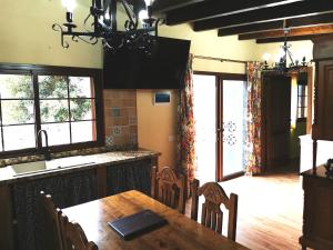 a kitchen with a dining table and a large window at Finca Tomás y Puri in Fátaga