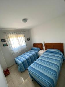 デニアにあるApartamento Aguamarのベッド3台が備わる部屋