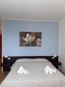 Un dormitorio con una cama con toallas blancas. en Magnolia Room & Breakfast, en Faenza