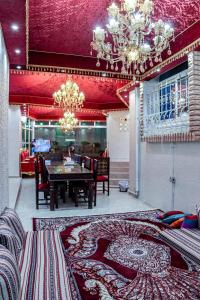 a dining room with a table and chairs and a rug at Staycation Home Shj in Sharjah