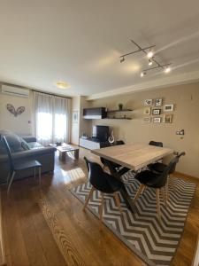 uma sala de estar com uma mesa de madeira e cadeiras em Apartament Neret I em Sort