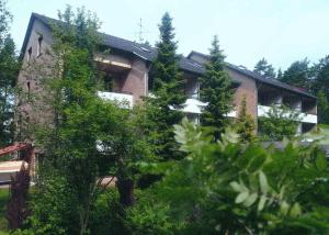 una casa grande con árboles delante de ella en Delux-FeWo - ThermePlus mit 2 Schlafzimmern, en Bad Bevensen