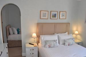 a bedroom with a bed with pillows and a mirror at The Castleton in Swanage