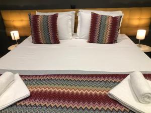 - un grand lit avec 2 oreillers et des serviettes dans l'établissement Metropolitan Complex Suite Faliro, au Pirée