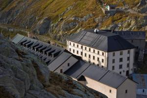 ein Gebäude an der Seite eines Berges in der Unterkunft Auberge de l'Hospice in Gebirgspass Grosser St. Bernhard