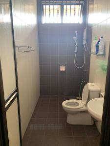 a bathroom with a toilet and a sink at VillaParadise Homestay in Batu Pahat +14 photos