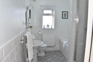 a white bathroom with a toilet and a sink at The Castleton in Swanage