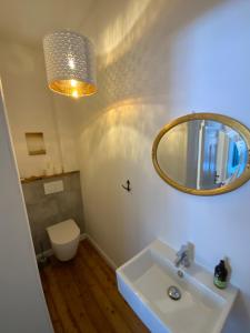 a bathroom with a sink and a mirror and a toilet at FeWoEck Kogge in Eckernförde +10 photos