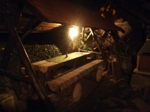 a picnic table with a surfboard on it at night at Cabana Farmec Ciubăr - Dézsabáj Kulcsosház in Sovata