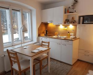 a kitchen with a wooden table and a table and chairs at Grüne Wiese - Gäste-Minibungalow in der Edermühle in Grosspertholz