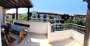a balcony with a wooden table and a bench at Family Hotel Littoral in Sozopol