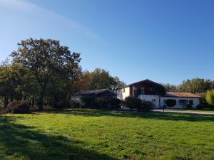 um quintal com uma casa e um campo de relva em LA PLANETTE em Aussonne