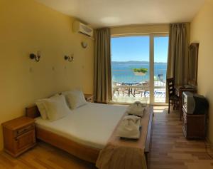 a bedroom with a bed with a view of the ocean at Family Hotel Littoral in Sozopol