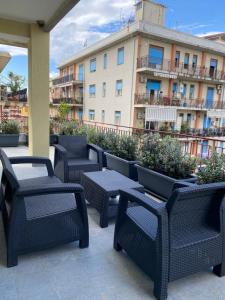 Un patio con sillas y mesas frente a un edificio. en ViCo HomeSuite, en Milazzo