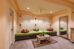SālāsarAnand Bagh Resort & Spa by Ananta的一间设有绿色沙发和一张桌子的客房