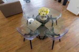 una mesa de cristal con un jarrón de flores. en Villa Royal en Rab
