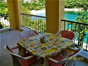 a table and chairs on a balcony with a view of the water at VILLAMAR beachfront apartments with FREE private parking in Rabac