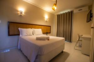 a bedroom with a large white bed in a room at Pousada Aruana Praia in Aracaju