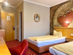 a hotel room with two beds and a heart wall at Querfurter Hof in Querfurt