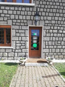 a stone building with a door and two toilets in front of it at Fouettara in Firminy